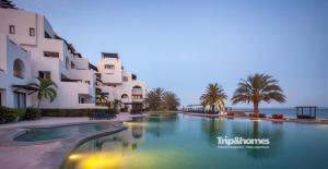 a swimming pool in front of a building at Casa Marvela at Playa de La Paz - 4br Beach front Villa, Access to Beach Club in La Paz