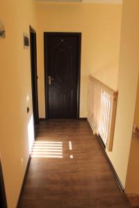 um corredor com uma porta preta e um piso de madeira em Къща за гости Българи em Triavna