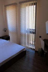 um quarto com uma cama, uma secretária e uma janela em Къща за гости Българи em Triavna