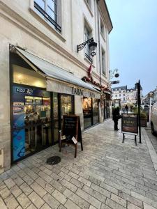 a shop on a street with signs on the sidewalk at Le Bijou du Martroi in Orléans