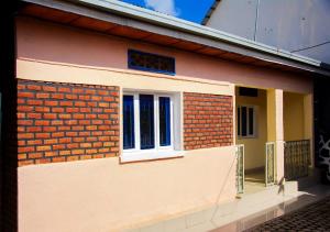 a house with a brick wall and two windows at Under Volcano Village 1 in Ruhengeri