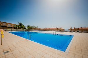 ein Pool in einem Resort mit blauem Wasser in der Unterkunft Sunshine Luxury Vacation House in Puerto de Santiago