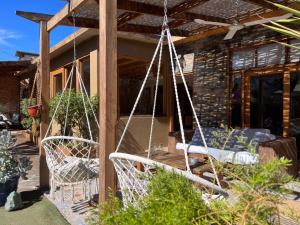 - une terrasse couverte avec 2 fauteuils roulants en face d'une maison dans l'établissement Hostal Villa Italo, à Copiapó