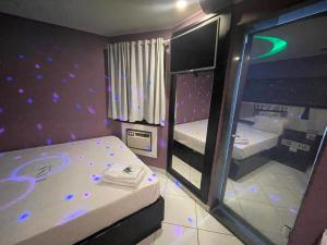 Cette petite chambre comprend 2 lits et un miroir. dans l'établissement Motel Messalina, à São Paulo