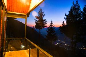 a room with a balcony with a view of the mountains at Montane Chalet , Sethan in Manāli