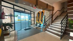 un vestíbulo de un edificio con escaleras y una puerta en Afford Hotéis en Lages