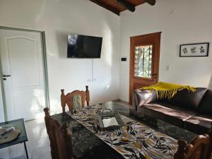 uma sala de estar com uma mesa e um sofá em Raíces serranas em Villa de Las Rosas