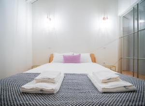 a bedroom with a bed with two towels on it at OportoCityView - Almada Luxury in Porto