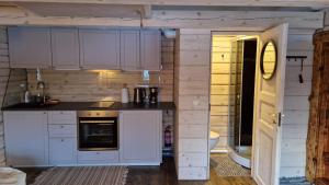 a kitchen with white cabinets and an open door at Leeotsa Talu Ait 