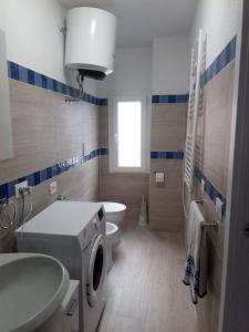 a bathroom with a washing machine and a sink and a toilet at SWEET LIANA un tuffo nel cuore del paese in Porto Santo Stefano