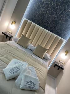 una camera da letto con un grande letto con due cuscini bianchi di Sunny Suite Napoli a Napoli