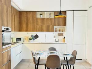 uma cozinha com mesa e cadeiras num quarto em [Porta Nuova - Alpitour] Free Parking & Netflix em Turim