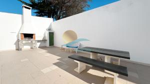 un patio con banco y chimenea en Villa Bea by Sunny Deluxe, en Albufeira