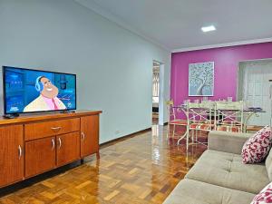 a living room with a flat screen tv on a dresser at Apt Centro de Foz, para até 8 pessoas com garagem in Foz do Iguaçu