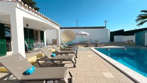 a pool with chaise lounge chairs next to a swimming pool at Villa Bea by Sunny Deluxe in Albufeira