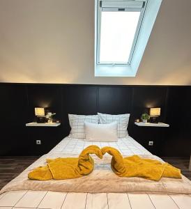 un letto con una coperta gialla e una finestra di Duplex, parking gratuit privé, 5min centre Auxerre a Monéteau