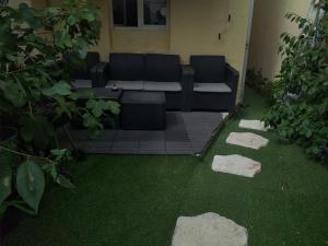een patio met een bank en wat gras en rotsen bij 3 Chambres à louer à COLOMBES in Colombes