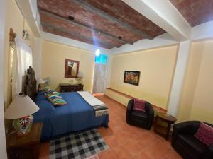 a bedroom with a blue bed and a chair at Casa Zuniga B&B in Guanajuato