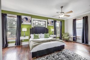 a bedroom with a bed with green walls and windows at Stylish Home in Springfield Historic District! in Jacksonville