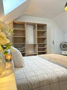 een slaapkamer met een bed en enkele planken bij Duplex, parking gratuit privé, 5min centre Auxerre in Monéteau