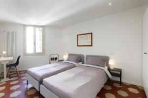 a white bedroom with a large bed and a desk at 25 Lazzaro Bonamigo in Bassano del Grappa