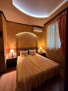 a bedroom with a large bed with two lamps at Guesthouse Petra in Veliko Tŭrnovo