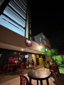 un restaurante con mesa y sillas por la noche en Expresso R1 Hotel Economy Suites en Maceió