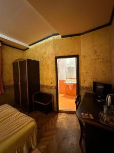 a bedroom with a bed and a desk and a window at Guesthouse Petra in Veliko Tŭrnovo