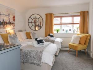 a bedroom with two beds and a couch and a window at Flat 2, The Maltings in Oakham