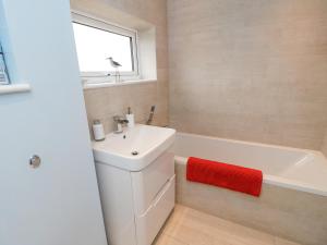 a bathroom with a white sink and a bath tub at Sea House in Littlehampton +32 photos