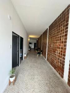 un couloir vide avec un mur et des chaises en briques dans l'établissement Don Enrique Bar&Hostel, à San Gregorio