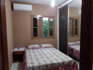 een slaapkamer met 2 bedden en een spiegel bij Casa de praia in Florianópolis