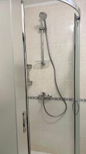 a shower with a hose in a bathroom at ELEA Apartment Mountain Lodge Pamporovo in Pamporovo