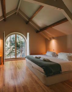 ein Schlafzimmer mit einem großen Bett und einem großen Fenster in der Unterkunft Aparthotel Oporto Palace in Porto