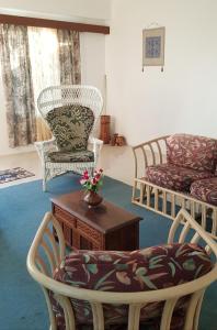 ein Wohnzimmer mit Stühlen, einem Tisch und einem Stuhl in der Unterkunft Jetpoint Furnished 2 bedroom in Nadi