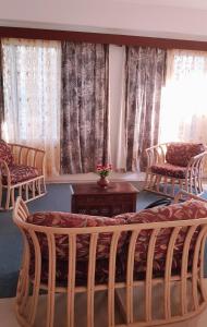 ein Wohnzimmer mit Stühlen, einem Tisch und Fenstern in der Unterkunft Jetpoint Furnished 2 bedroom in Nadi