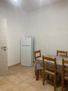 a dining room with a table and a refrigerator at Casa vacanze paola in Porto Empedocle