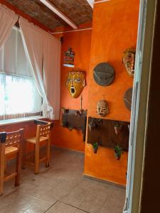 a room with orange walls and a table and chairs at Casa Zuniga B&B in Guanajuato