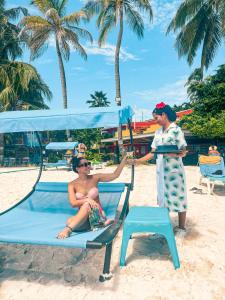 Ein Mann und eine Frau auf einem Strandkorb in der Unterkunft Hotel Cocoplum Beach in San Andrés