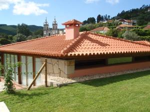 een huis met een betegeld dak in een veld bij Casa da Boa Fonte in Ponte de Lima