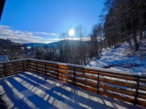 a snow covered bench with a view of the mountains at Chalety Bystrá in Bystrá