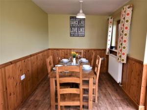 a dining room with a wooden table and chairs at 3 Bed in Ledbury 77378 