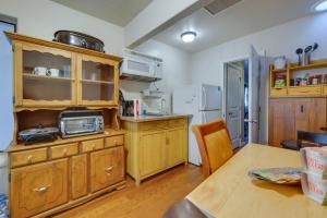 a kitchen with wooden cabinets and a wooden table at Cozy Mesa Vacation Rental with Shared Yard and Hot Tub in Mesa