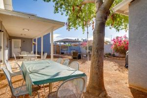 a patio with a table and chairs and a tree at Cozy Mesa Vacation Rental with Shared Yard and Hot Tub in Mesa