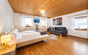- une chambre avec un grand lit et un canapé dans l'établissement Alpen Appartements Marlene, à Ehrwald