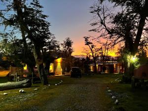 une maison avec une voiture garée dans une cour au coucher du soleil dans l'établissement Cabañas La Querencia Tolhuin, à Tolhuin