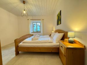 een slaapkamer met een bed, een tafel en een raam bij Ferienwohnungen Palma in Cortaccia