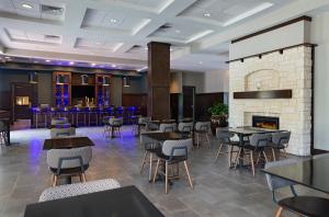 a restaurant with tables and chairs and a fireplace at Four Points by Sheraton Houston West in Houston