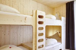 2 łóżka piętrowe w pokoju z drewnianymi ścianami w obiekcie Hotel Obermoosburg w mieście Coldrano