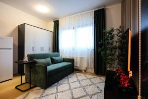 a living room with a green couch and a window at Modern Luxe Haven in Zagreb